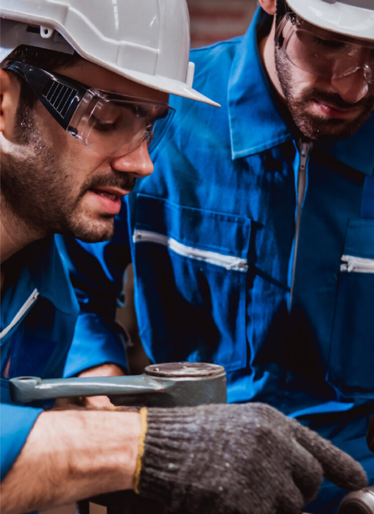 Personal capacitado con equipo de seguridad inspeccionando maquinaria crítica durante procesos industriales