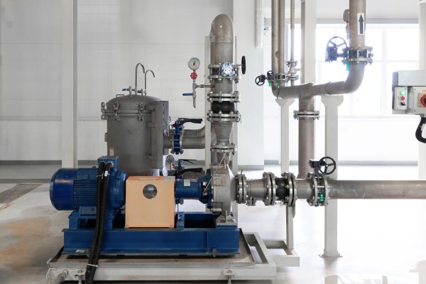 Equipo de bombas industriales de precisión acopladas a un tanque de presión y sistema de tuberías aéreas con válvulas