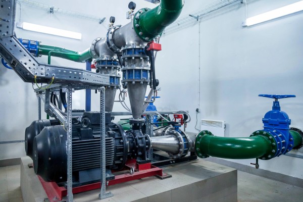 Gran unidad de bombas industriales conectadas a tuberías metálicas de gran diámetro en un entorno industrial complejo
