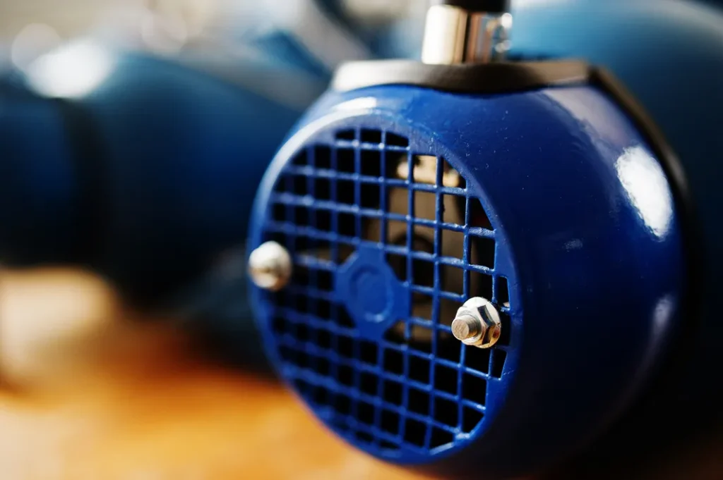 Detalle en primer plano de la rejilla de ventilación de una bomba de agua industrial azul con enfoque artístico.