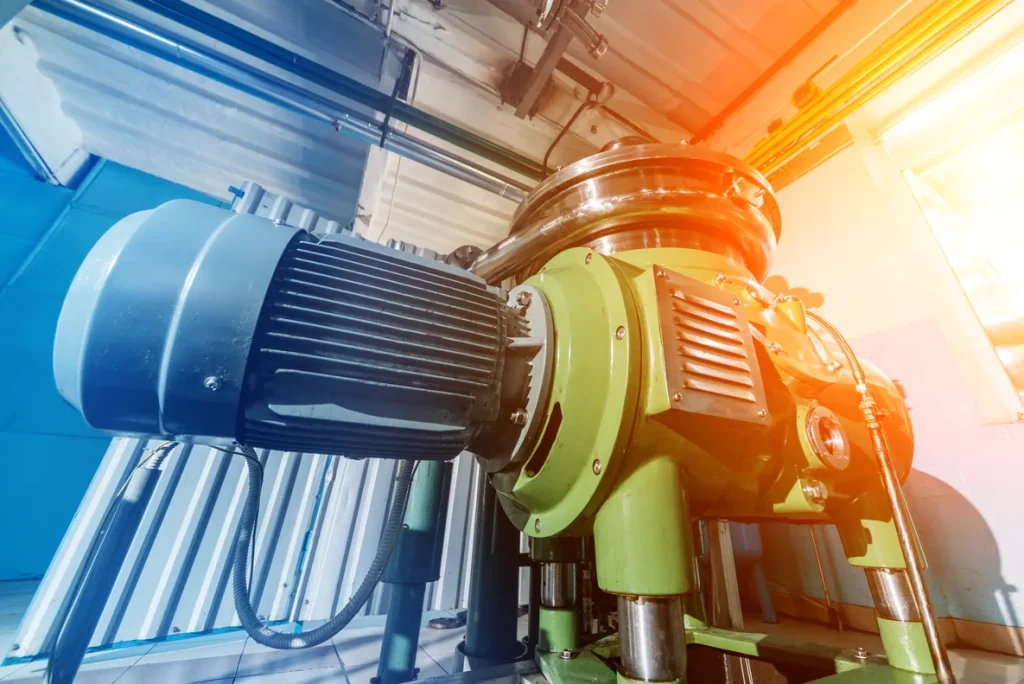 Motor eléctrico de gran escala en planta fabril recibiendo mantenimiento industrial preventivo bajo iluminación técnica.