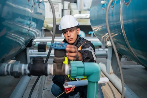 Especialista en seguridad industrial aplica mantenimiento preventivo en las válvulas de presión de tanques exteriores.