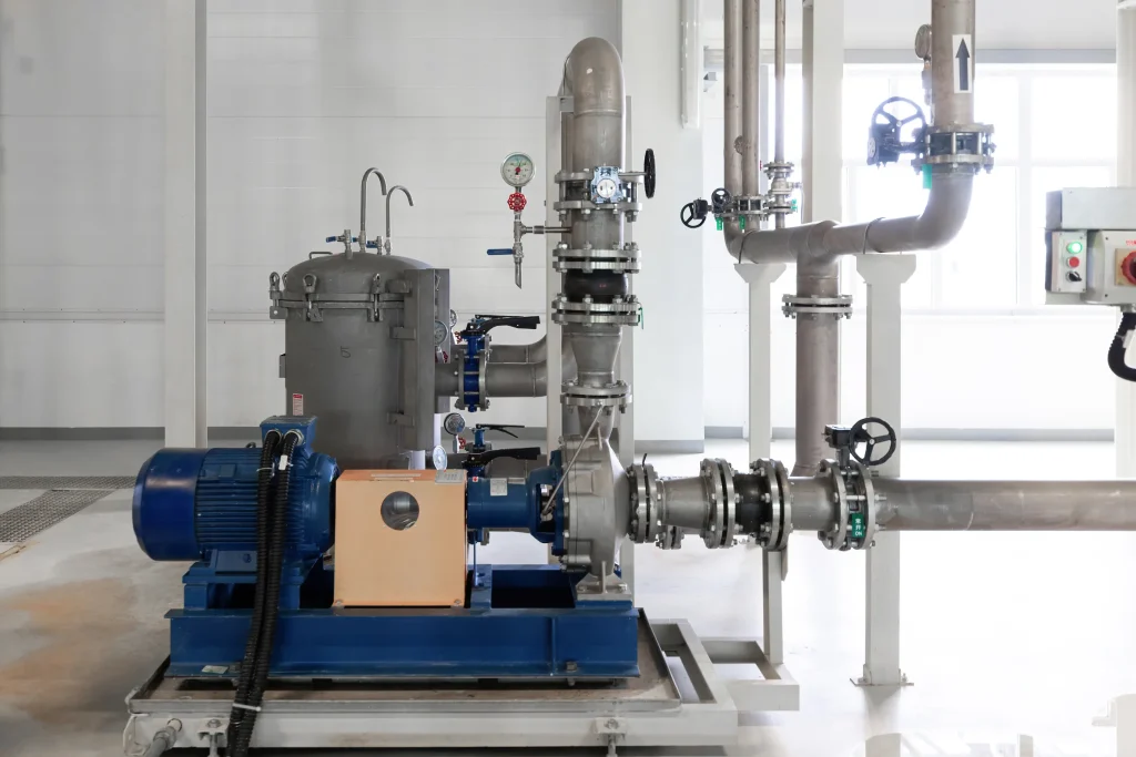 Uno de los tipos de bombas industriales centrífugas con motor eléctrico y tuberías en una planta limpia.